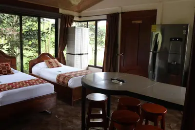 a room with two beds and a table and a refrigerator at Cabinas Sueño Real in San Rafael