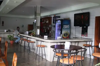 a man sitting at a bar in a restaurant at Cabinas Sueño Real in San Rafael