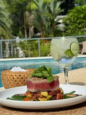 a plate of food and a glass of wine at Aves Resort Montezuma in Montezuma
