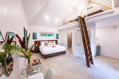 a bedroom with a bed and a loft at Aves Resort Montezuma in Montezuma
