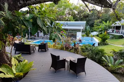 a patio with chairs and a table and a pool at Aves Resort Montezuma in Montezuma