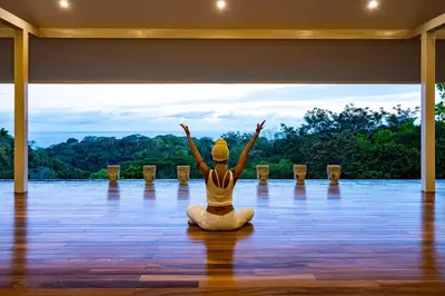 a woman sitting in a yoga position on a floor at Aves Resort Montezuma in Montezuma