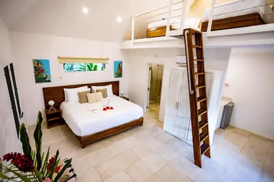 a bedroom with a bed and a ladder in a room at Aves Resort Montezuma in Montezuma