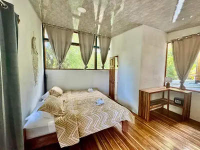 a bedroom with a bed in a room with a window at El Gato Rojas Surf Hostel in Santa Teresa Beach