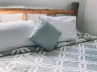 a bed with two pillows on top of it at El Gato Rojas Surf Hostel in Santa Teresa Beach