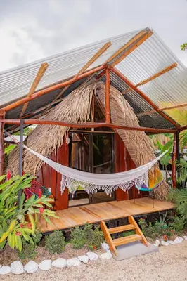 a small hut with a hammock in front of it at El Gato Rojas Surf Hostel in Santa Teresa Beach