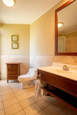 a bathroom with a sink and a toilet and a mirror at Tropical 2BR Condo with Partial Ocean View - Bougainvillea - Reserva Conchal in Playa Conchal