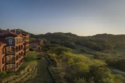 an aerial view of a resort building with a view of a golf course at Tropical 2BR Condo with Partial Ocean View - Bougainvillea - Reserva Conchal in Playa Conchal
