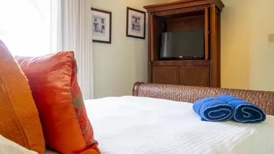 a blue towel sitting on a bed with a television at Luxury 3BR Condo with Partial Ocean View - Bougainvillea - Reserva Conchal in Playa Conchal