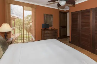 a bedroom with a bed and a large window at Luxury 3BR Condo with Partial Ocean View - Bougainvillea - Reserva Conchal in Playa Conchal
