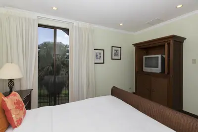 a bedroom with a bed and a tv and a window at Luxury 3BR Condo with Partial Ocean View - Bougainvillea - Reserva Conchal in Playa Conchal