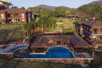 an aerial view of a house with a swimming pool at Luxury 3BR Condo with Partial Ocean View - Bougainvillea - Reserva Conchal in Playa Conchal