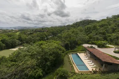 an aerial view of a house with a swimming pool at Cozy 1BR Condo with Partial Ocean View - Roble Sabana - Reserva Conchall in Playa Conchal