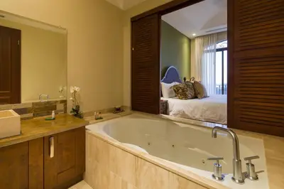 a bathroom with a large tub and a bedroom at Incredible Ocean-View Penthouse - Jobo - Reserva Conchal Golf Resort in Playa Conchal