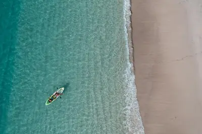 an overhead view of a boat in the water next to a beach at Incredible Ocean-View Penthouse - Jobo - Reserva Conchal Golf Resort in Playa Conchal
