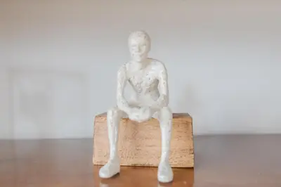 a white statue of a man sitting on a box at Apt AC WIFI Mountain View Near beach Costa Rica in Jacó