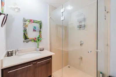 a bathroom with a sink and a glass shower at Apt AC WIFI Mountain View Near beach Costa Rica in Jacó