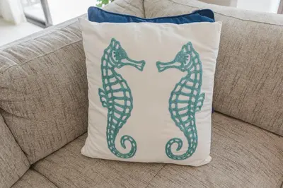 two seahorses on a pillow on a couch at Apt AC WIFI Mountain View Near beach Costa Rica in Jacó