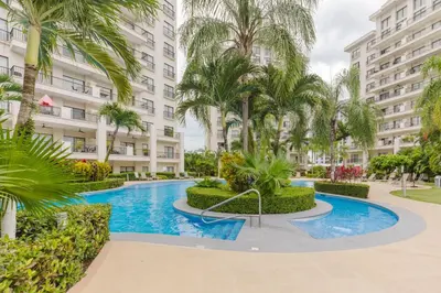 an apartment complex with a swimming pool and palm trees at Apt AC WIFI Mountain View Near beach Costa Rica in Jacó