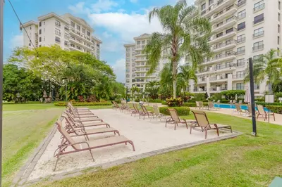 a row of chairs in a park with buildings at Apt AC WIFI Mountain View Near beach Costa Rica in Jacó