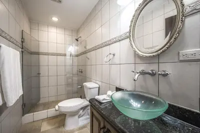 a bathroom with a sink and a toilet and a mirror at Corona del Mar #6 in Ocotal