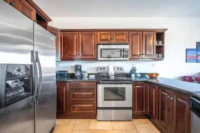 a kitchen with wooden cabinets and a stainless steel refrigerator at Corona del Mar #6 in Ocotal