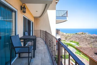 a balcony with chairs and a view of the ocean at Corona del Mar #6 in Ocotal