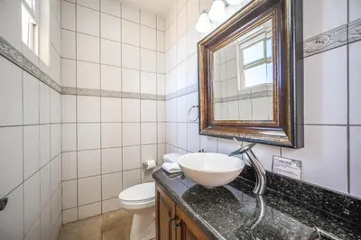 a bathroom with a sink and a mirror and a toilet at Corona del Mar #6 in Ocotal