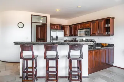 a kitchen with a counter and two bar stools at Corona del Mar #6 in Ocotal