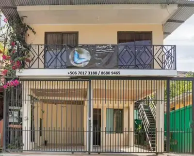 a building with a balcony with a sign on it at Habitación Privada - Apartamentos Morpho CR in Quepos