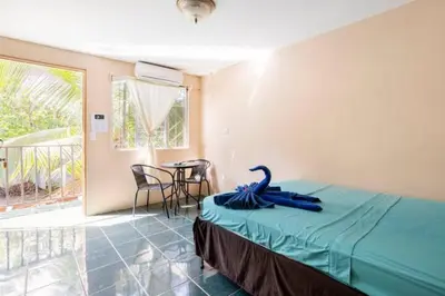 a room with a bed and a table with chairs at Habitación Privada - Apartamentos Morpho CR in Quepos