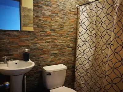 a bathroom with a white toilet and a sink at Habitación Privada - Apartamentos Morpho CR in Quepos