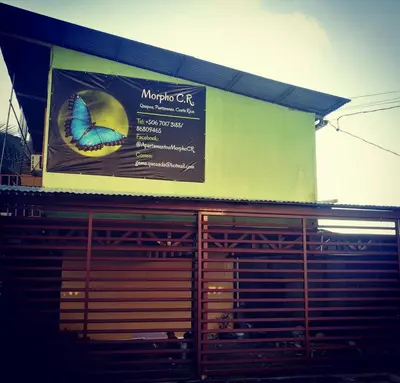 a sign on a building with a butterfly on it at Habitación Privada - Apartamentos Morpho CR in Quepos