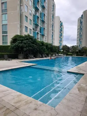 a large swimming pool in a city with tall buildings at Lujoso condominio con lavadora y secadora, S. José in San José