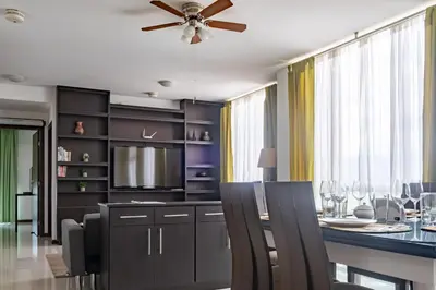 a dining room with a table and a ceiling fan at Lujoso condominio con lavadora y secadora, S. José in San José