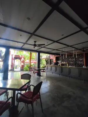 a restaurant with tables and chairs and a bar at Hotel Laguna del Cocodrilo in Tamarindo