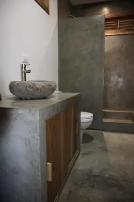 a bathroom with a stone sink and a toilet at Lucero in Santa Teresa Beach