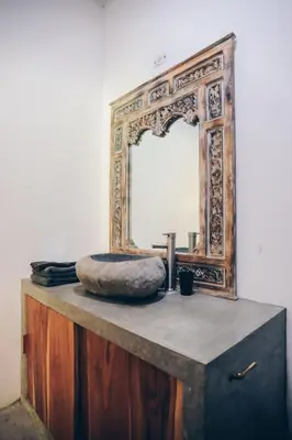 a mirror on top of a wooden dresser with a sink at Lucero in Santa Teresa Beach