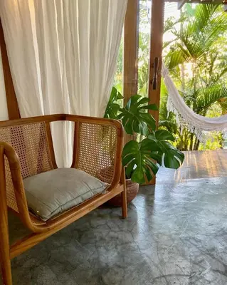 a wicker chair sitting on a porch with plants at Lucero in Santa Teresa Beach