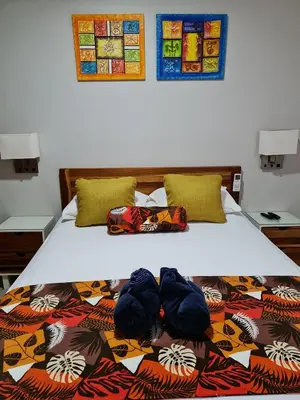 a bedroom with a bed with a colorful comforter at Ballena Paradise Apartahotel in Uvita