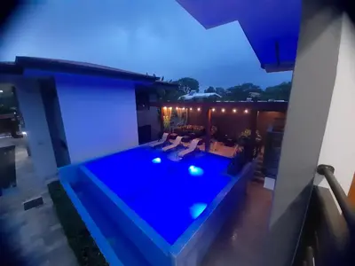 a backyard with a swimming pool at night at Ballena Paradise Apartahotel in Uvita