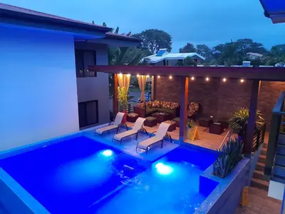 a backyard with a swimming pool at night at Ballena Paradise Apartahotel in Uvita