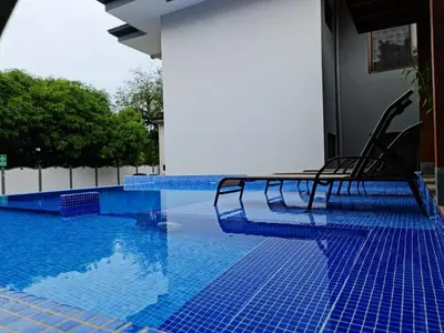 a row of chairs sitting next to a swimming pool at Ballena Paradise Apartahotel in Uvita