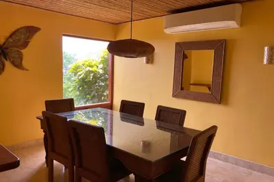 a dining room with a table and chairs and a mirror at Bahia Pez Vela Resort in Ocotal