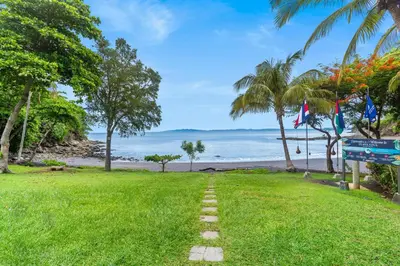 a path in the grass next to the beach at Bahia Pez Vela Resort in Ocotal