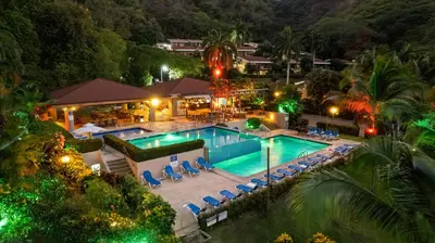 an aerial view of a resort pool at night at Bahia Pez Vela Resort in Ocotal