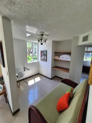 a living room with a couch and a bed at Family getaway, pool, beach and surf in Jacó