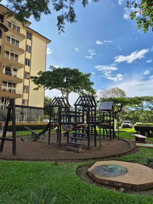 a playground in a park next to a building at Family getaway, pool, beach and surf in Jacó