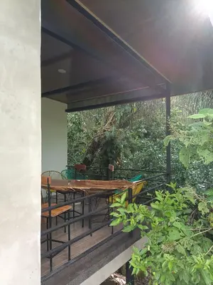 a wooden table and chairs on a deck at Selva Linda Lodge jungle wildlife vue and birdwatching in Quepos