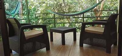 a porch with two chairs and a table and a hammock at Selva Linda Lodge jungle wildlife vue and birdwatching in Quepos